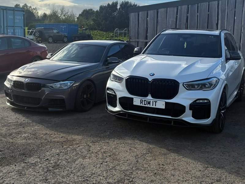 Two of Rob's cars: a grey BMW saloon and a white X5