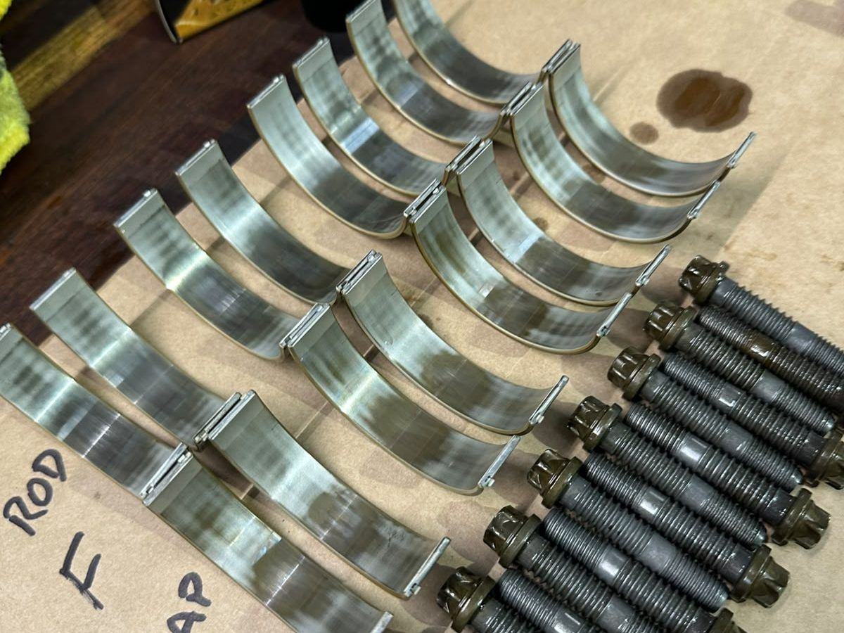 Rod bearing shells and new bolts laid out by position at RDM